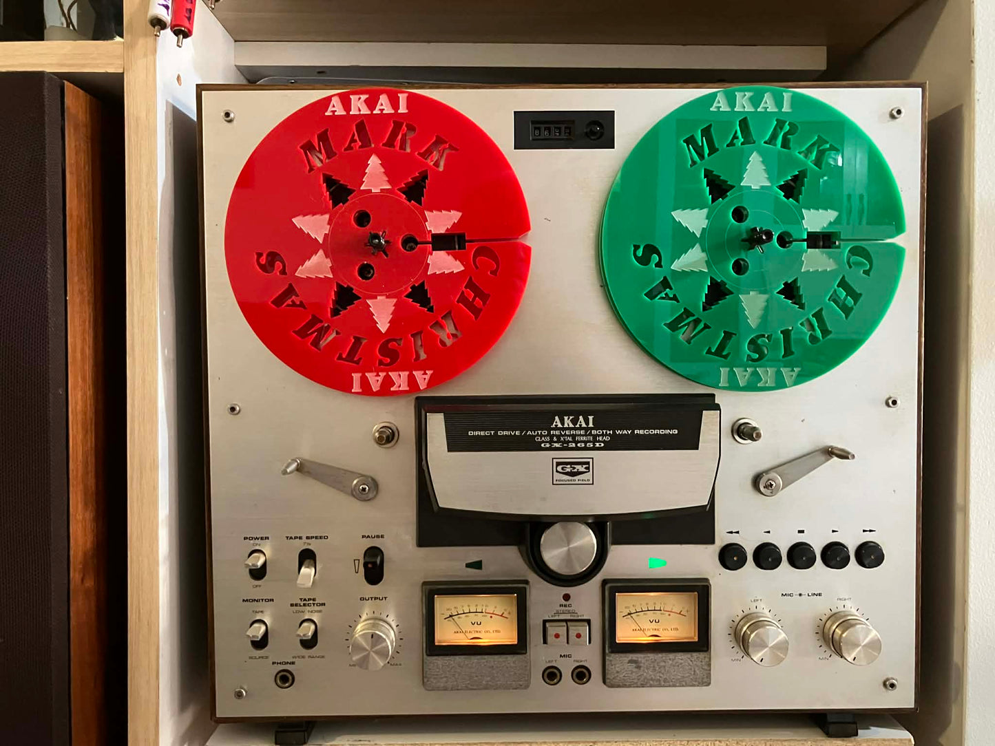 Vintage Akai reel-to-reel tape recorder with red and green reels.